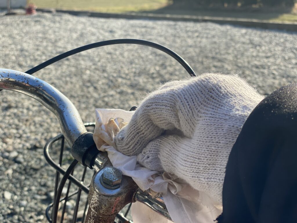 自転車のハンドルを乾いた布で拭き取る